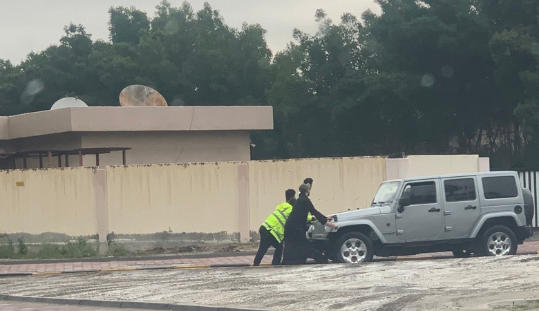 رجال المرور يشاركون بدفع مركبة تعطلت وسط الامطار